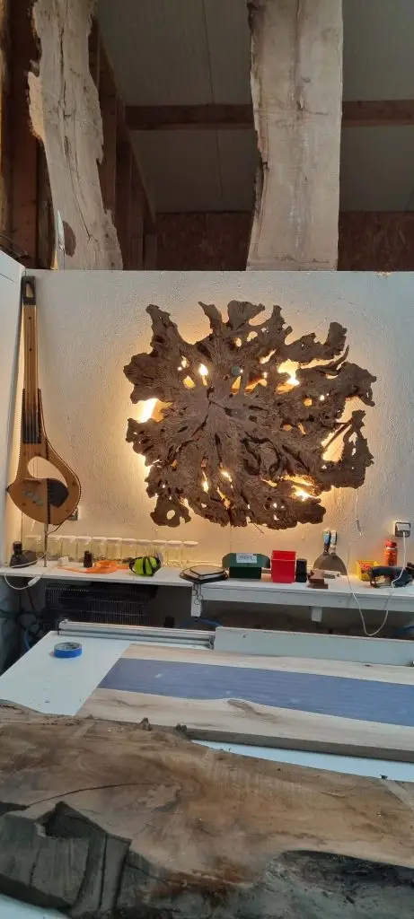 Applique murale artistique fabriquée à partir d'une racine de bois naturel rétroéclairée, installée dans un atelier d’ébénisterie à Stanwood-Bretagne. Pièce unique idéale pour une décoration intérieure rustique ou contemporaine.